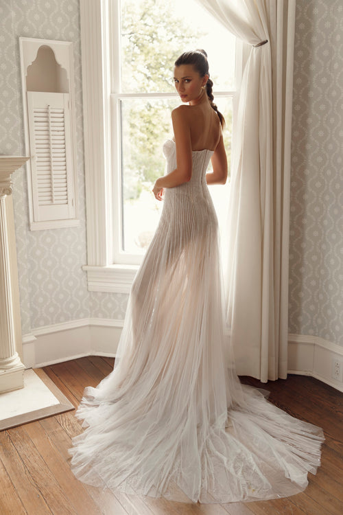Back view of Julie Vino Antonia 3205 wedding dress with linear beadwork, a fitted silhouette and an airy skirt flowing into a sweeping train.