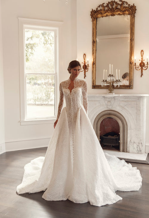 Front view of Julie Vino Collette 3207 lace ball gown wedding dress with long illusion sleeves, a high collar and a sculpted corset bodice.