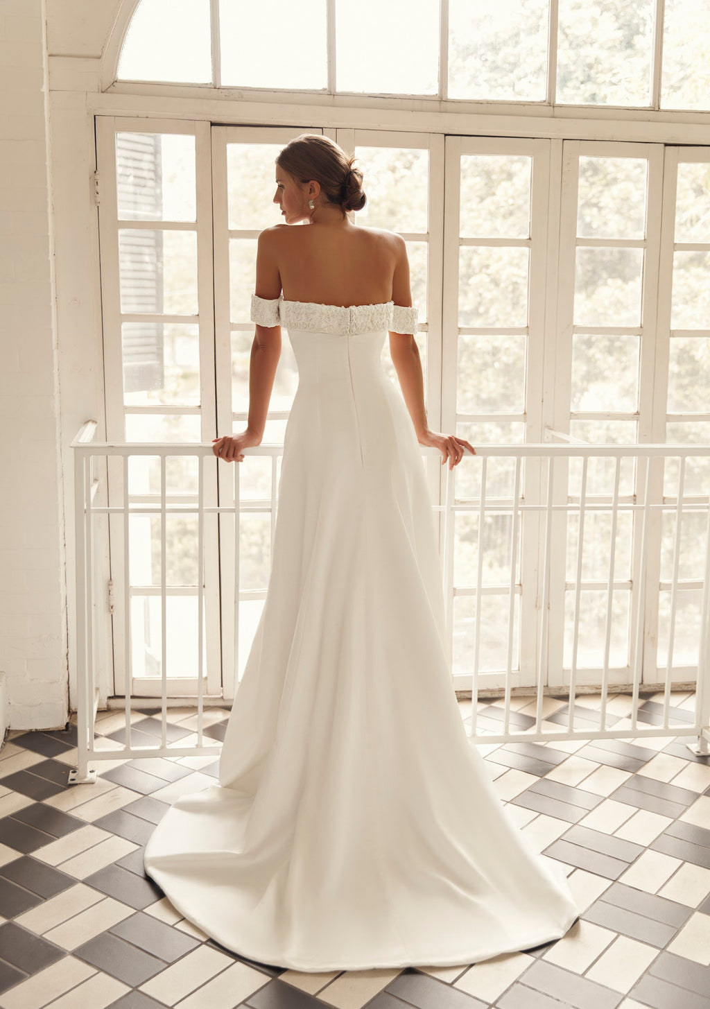 Back view of Mimosa by Julie Vino Ophelia MB27-24 off-shoulder wedding dress with floral trim, a softly flared skirt and sweeping train.