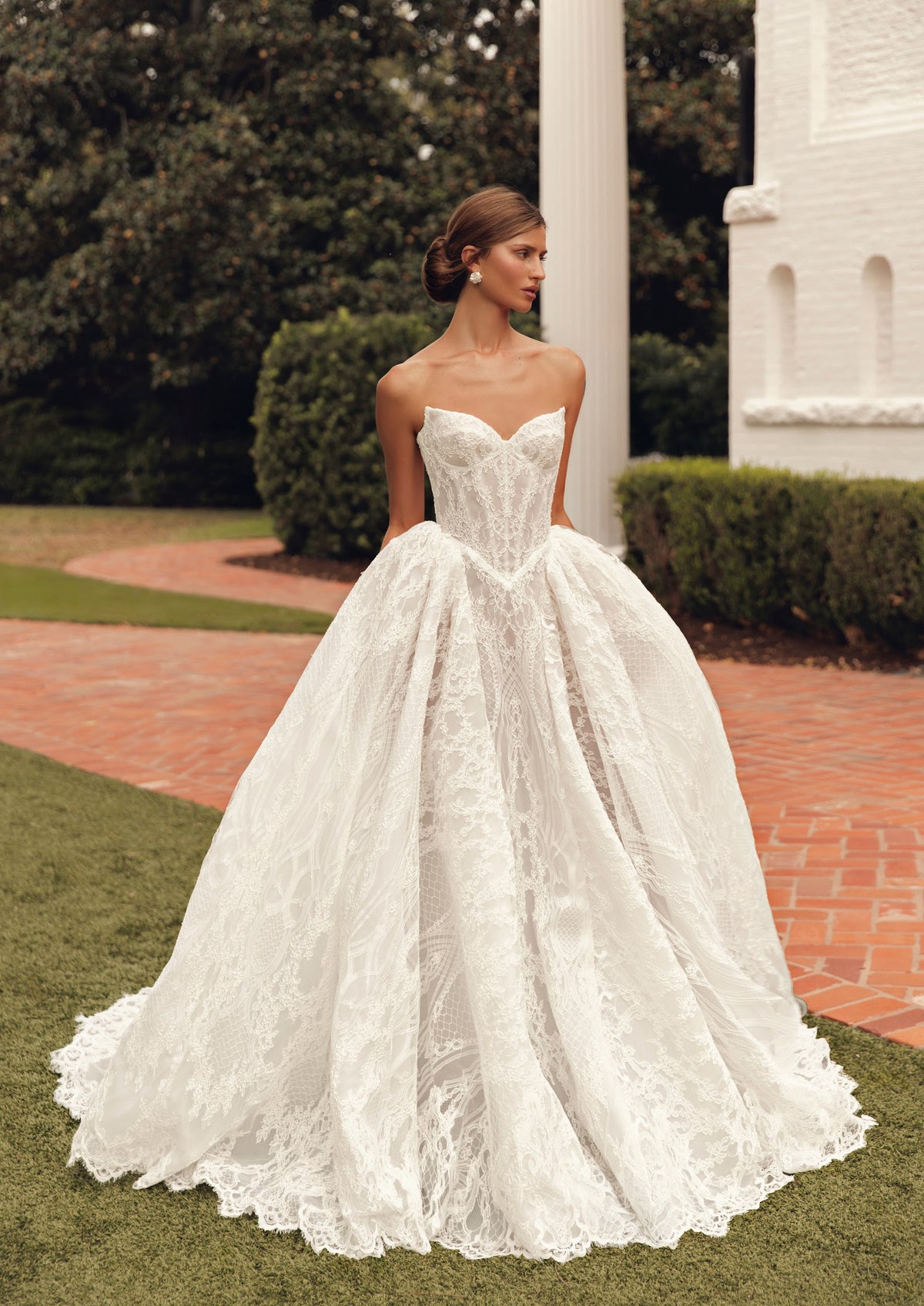 Mimosa by Julie Vino Jolie MB27-21 wedding dress showing a pointed corset waist, full lace skirt and coordinating long-sleeve lace topper.