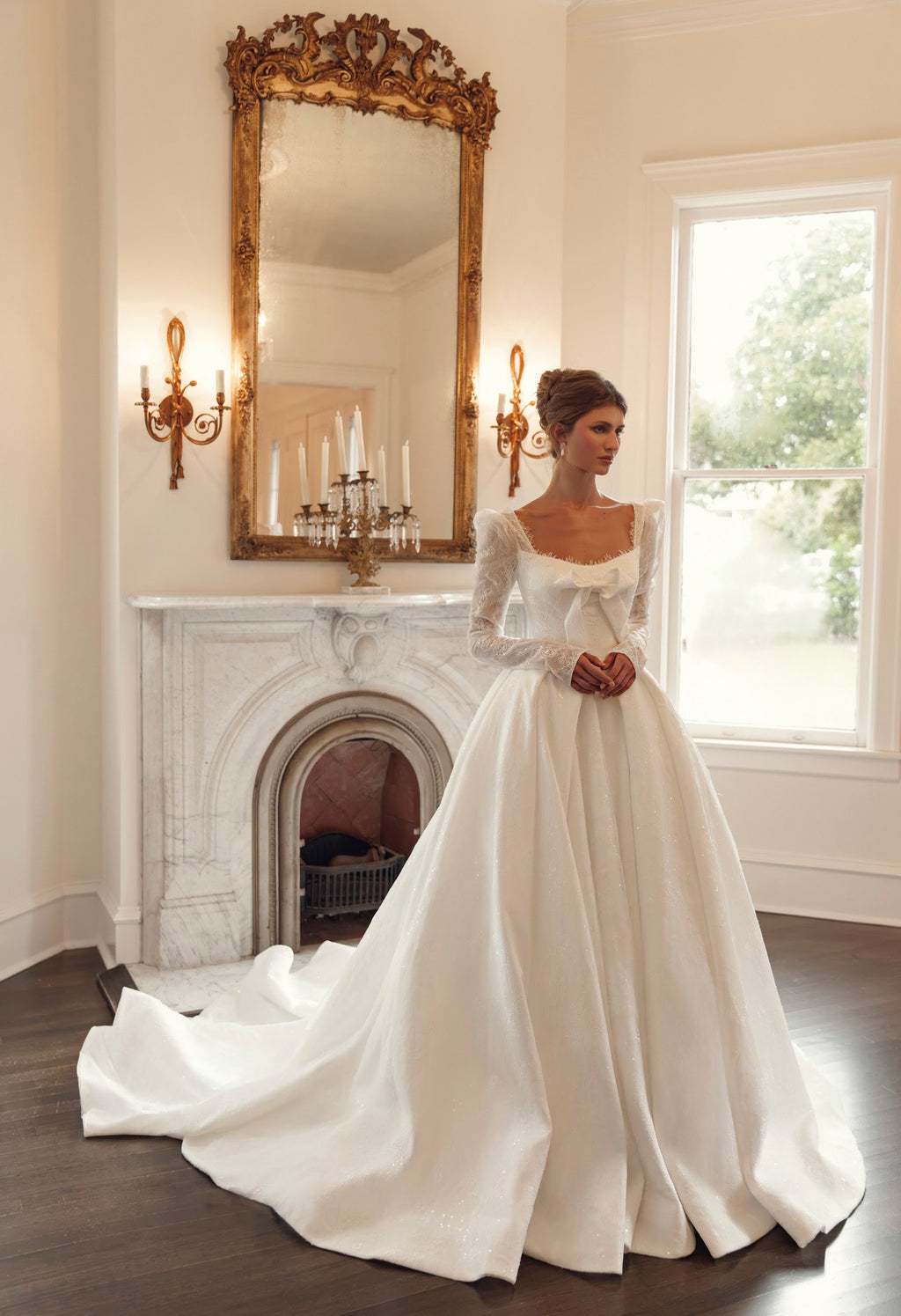 Front view of Mimosa by Julie Vino Nicoletta MB27-27 ball gown wedding dress with long illusion lace sleeves, a square neckline and statement bow.