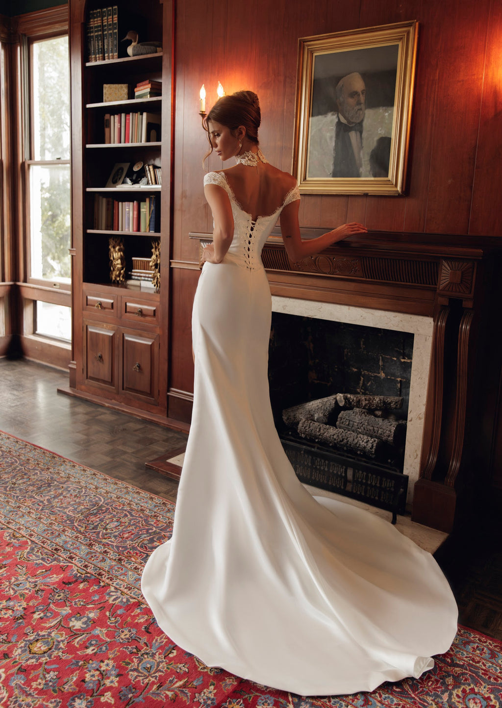 Back view of Estelle PR27-23 fitted gown by Pure by Julie Vino, showing the low lace-trimmed back, corset lacing and flowing train.