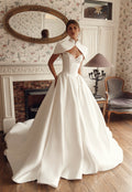 Front view of Mirella PR27-25 by Pure by Julie Vino, showing the lace sweetheart neckline and full pleated skirt, styled with a short bridal cape.