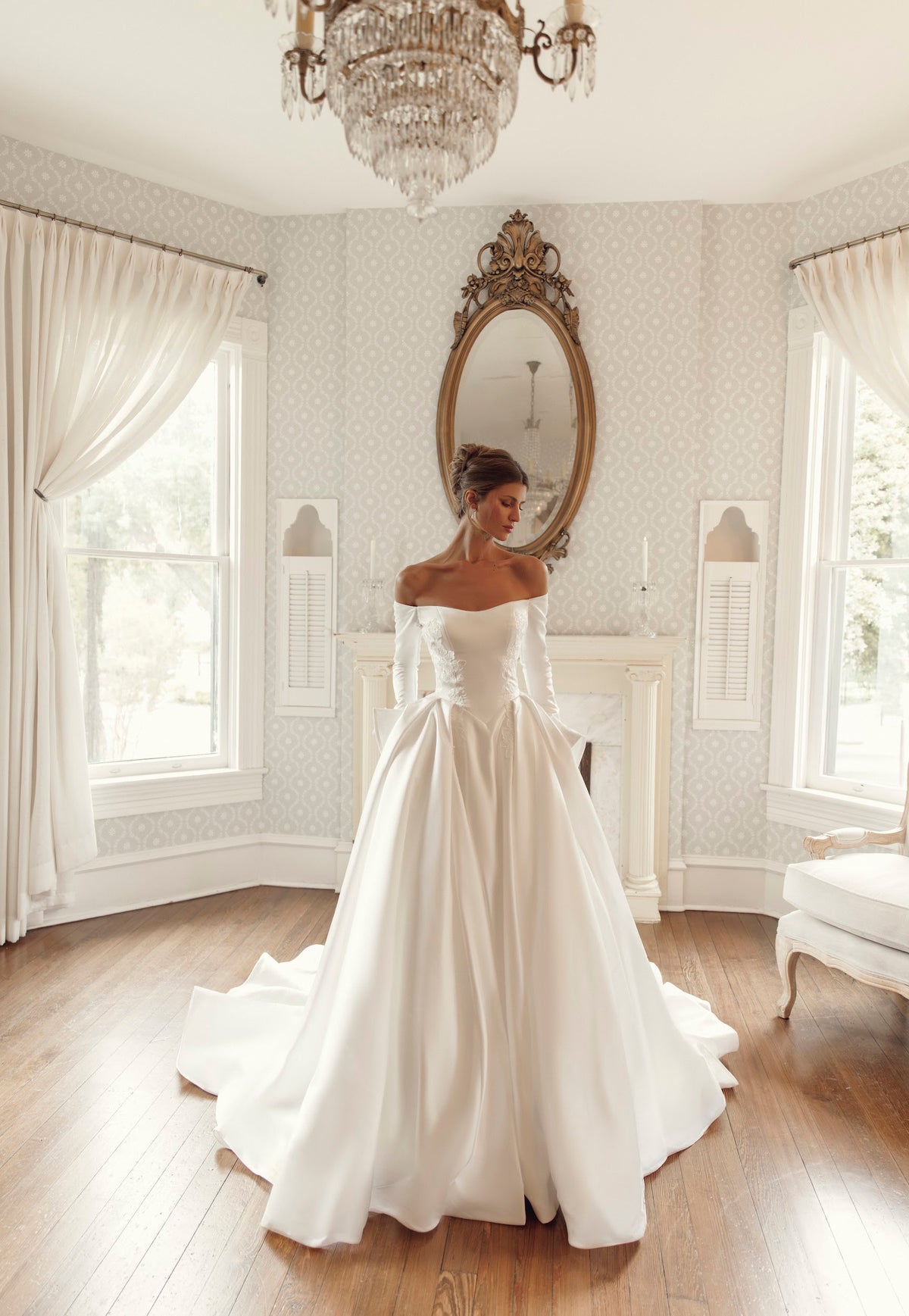 Discover Lisette PR27-26 by Pure by Julie Vino, an off-the-shoulder ball gown with long sleeves, floral lace accents, a pointed basque waist and sweeping train.