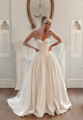 Front view of Fiorelle PR27-27 by Pure by Julie Vino, showing the pleated sweetheart neckline, pointed basque waist and full skirt, styled with a veil.